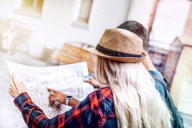 Couple élégant avec carte debout sur rue