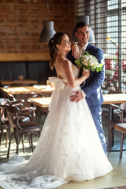 Un couple élégant se fait prendre en photo dans le restaurant après la cérémonie.