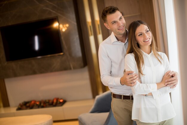 Couple embrassant debout dans le salon d'un appartement contemporain