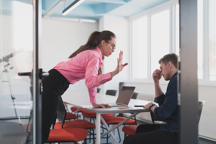 Photo couple émotionnel de jeunes collègues se disputant dans un bureau moderne. femme d'affaires criant à son assistant homme triste, espace copie, vue latérale.