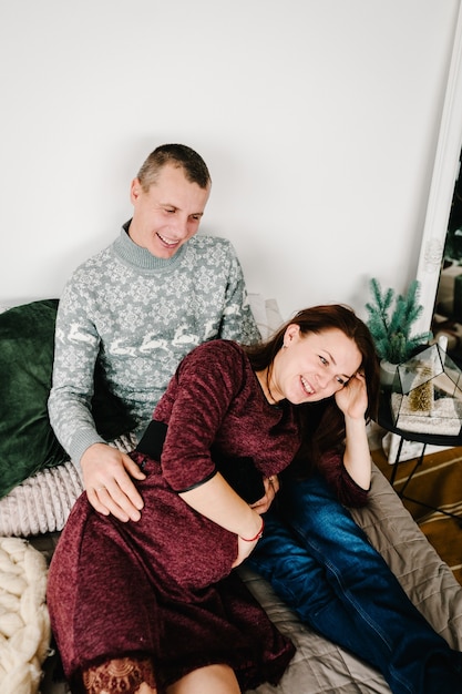 Couple enceinte allongé près de l'arbre de Noël Bonne année et joyeux Noël