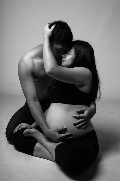 Couple enceinte heureux avec fond blanc.