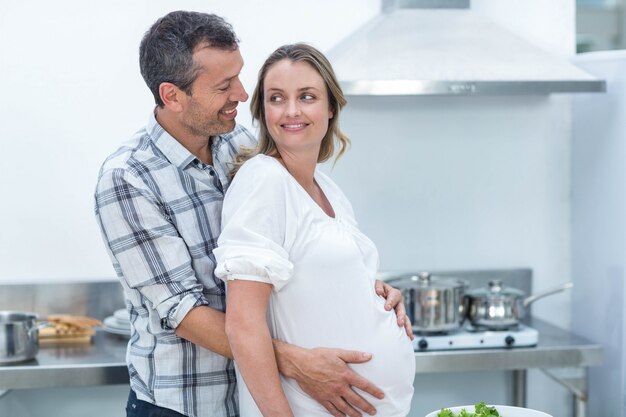 Photo couple enceinte en regardant la caméra dans la cuisine