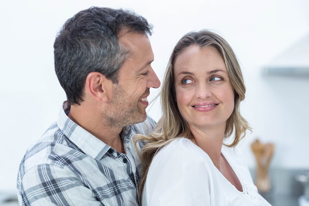 Couple enceinte en regardant la caméra dans la cuisine