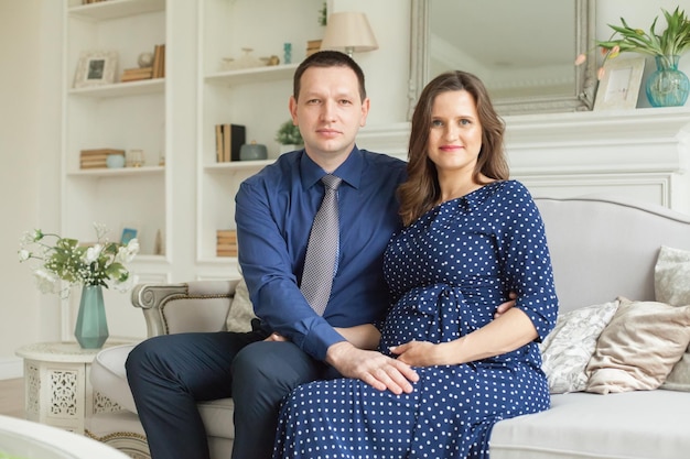 Couple enceinte souriant à la maison