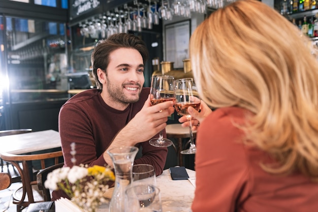 Couple énergique enthousiaste, boire du vin et se balancer