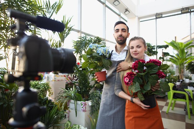 Un couple enregistre une vidéo pour le contenu des médias sociaux, une belle photo dans un jardin botanique avec des fleurs