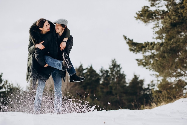 Couple ensemble dans un parc d'hiver s'amusant