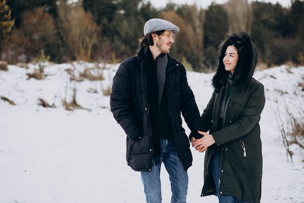 Couple ensemble dans un parc d'hiver s'amusant