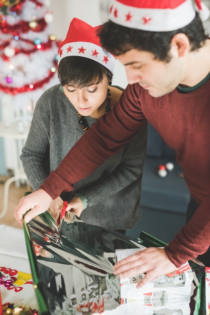 couple enveloppant les cadeaux de Noël