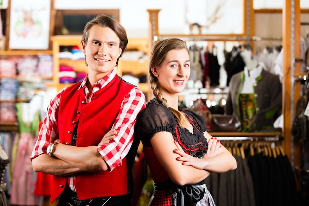 Couple essaye Dirndl ou Lederhosen dans un magasin