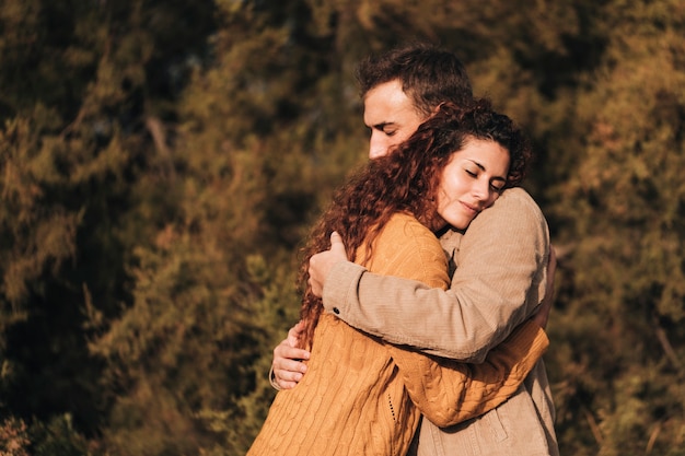 Couple étreignant latéralement à l'extérieur
