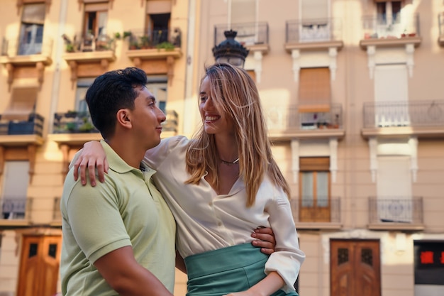 Couple étreignant et souriant à la lumière du soleil