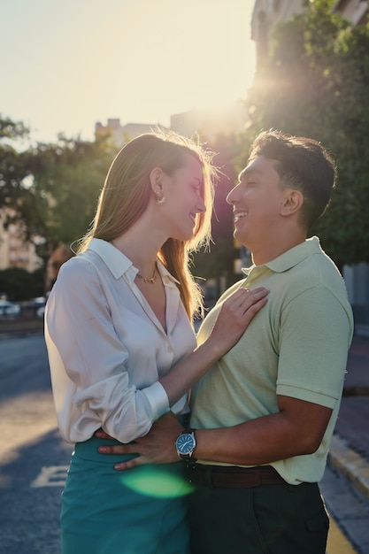 Couple étreignant et souriant à la lumière du soleil