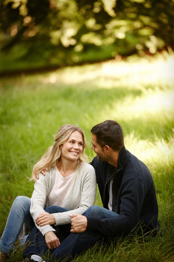 Photo couple étreint et à l'extérieur l'amour sur l'herbe ensemble et les soins dans la relation ou l'attachement dans le parc les gens heureux soutiennent et embrassent en vacances ou en vacances dans la nature se détendre et s'engager à une date romantique