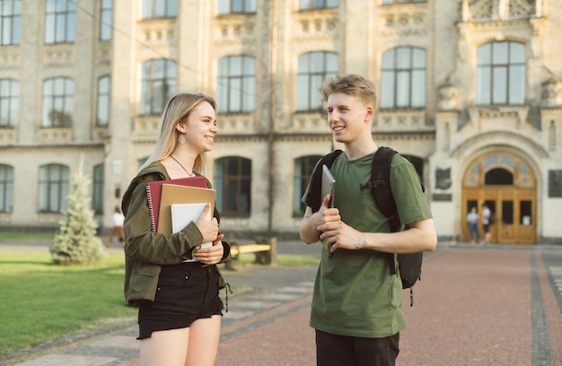 Couple d'étudiants debout près du collège