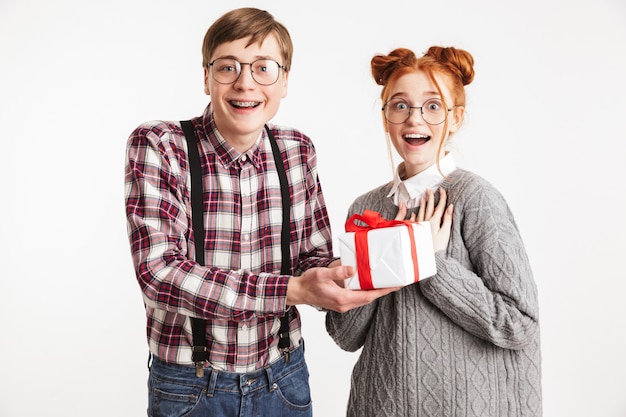 Couple excité de nerds de l'école donnant boîte cadeau