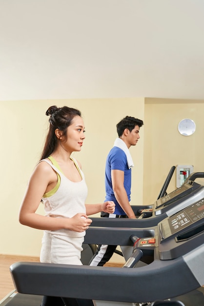 Couple exerçant sur des tapis roulants