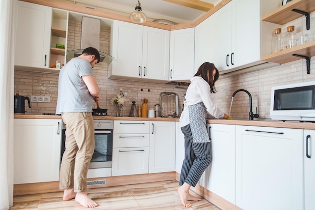 Couple faisant la cuisine sur la vaisselle de lavage de cuisine