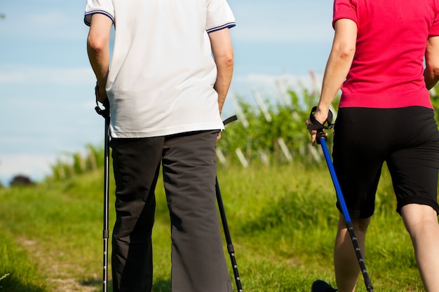 Couple faisant de la marche nordique en été