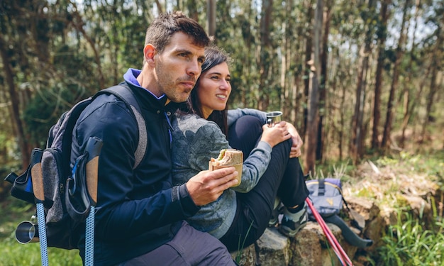 Couple faisant une pause tout en faisant du trekking