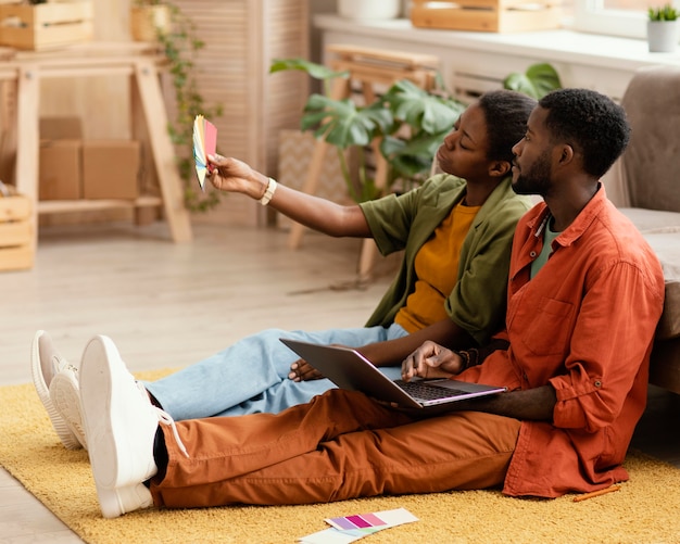 Photo couple faisant des plans pour rénover la maison à l'aide de la palette de couleurs