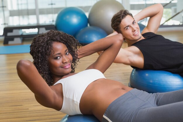 Couple faisant des redressements assis sur des balles d&#39;exercice