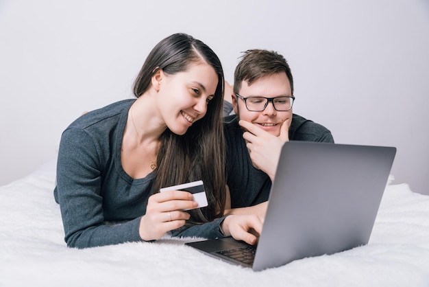 Un couple fait du shopping en ligne avec son ordinateur portable