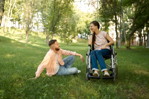 Couple de famille avec loisirs en fauteuil roulant dans le parc