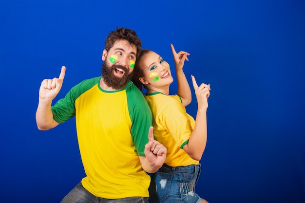 Couple de fans de football caucasiens du Brésil dansant