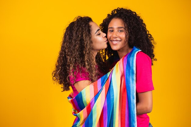 Couple femme lesbienne avec drapeau de la fierté gaie sur fond jaune