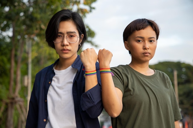 Couple de femmes LGBT confiantes restant ensemble avec le symbole du ruban arc-en-ciel concept de fierté LGBT personnes LGBTQ campagne pour les droits lgbt mariage homosexuel préférence sexuelle diversité dans la société moderne