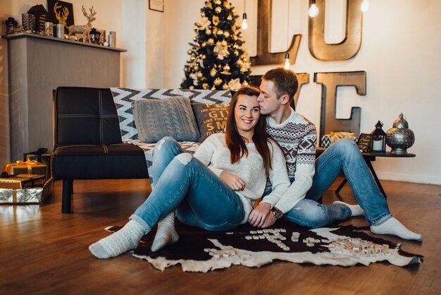 Un couple fête Noël dans une ambiance chaleureuse à la maison