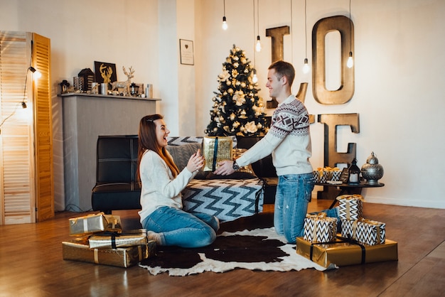 Un couple fête Noël dans une ambiance chaleureuse à la maison