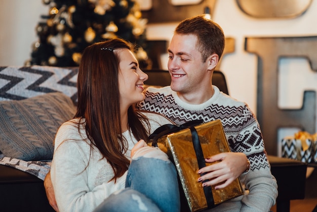 Un couple fête Noël dans une ambiance chaleureuse à la maison