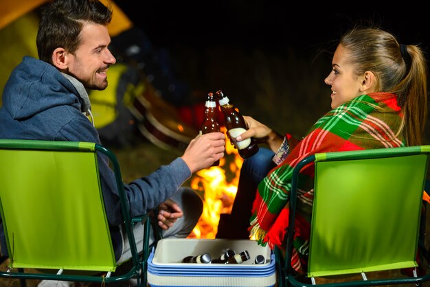 Couple, feu camp, camper, boire, bière