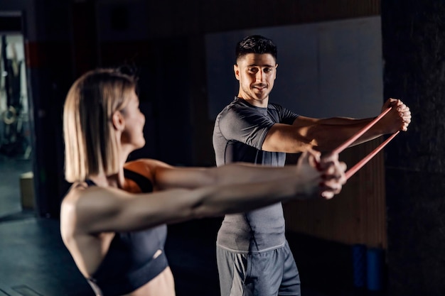 Un couple de fitness heureux excisant avec un groupe de fitness à la salle de sport