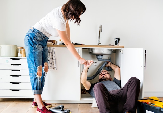 Couple fixant un évier de cuisine