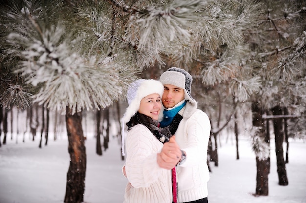 Couple sur le fond des arbres enneigés