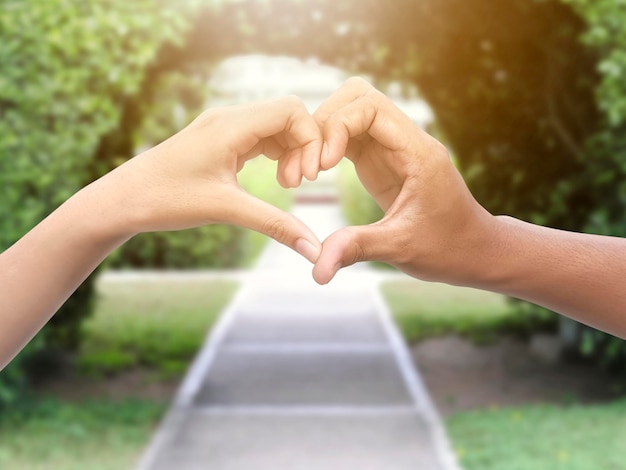 Couple en forme de coeur avec les mains dans le parc