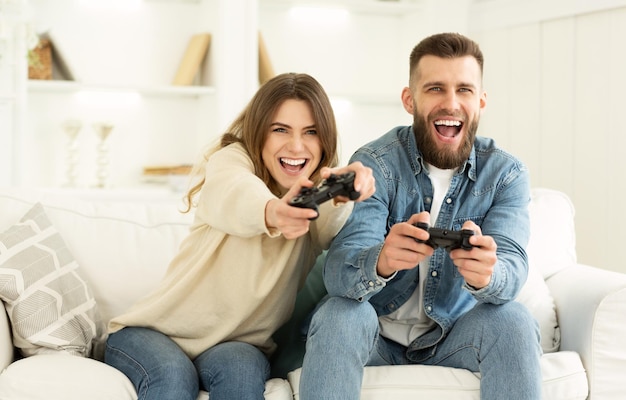 Couple fou appréciant de jouer à un jeu vidéo sur Playstation