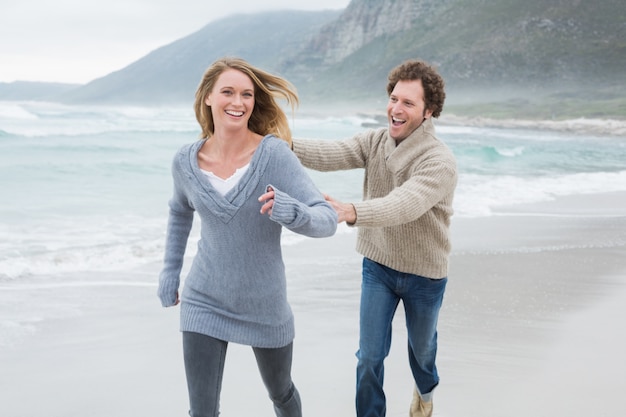 Couple gai courir sur la plage