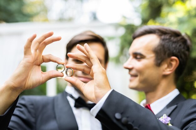 Photo un couple gai et joyeux tenant des bagues de mariage.