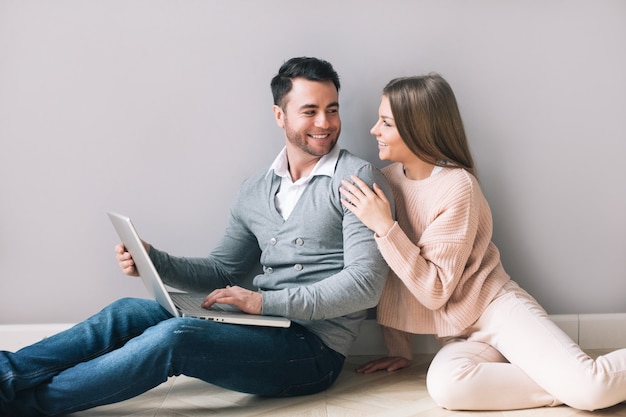 Couple gai avec ordinateur portable à la maison. Shopping en ligne.