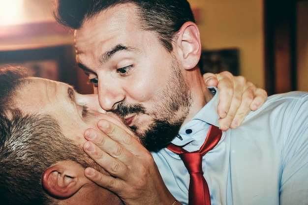 Couple gay aimant s'embrasser passionnément à la fête de mariage Deux beaux hommes ayant un baiser romantique à l'intérieur Concept de mariage et de droits LGBT