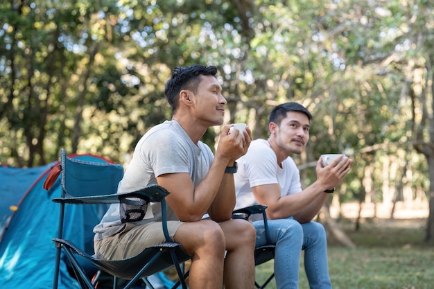 Un couple gay asiatique heureux en train de camper ensemble dans une forêt, un voyage de vocation romantique, un concept LGBT.