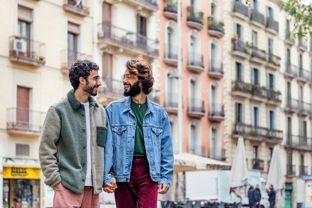 Couple gay marchant dans la ville main dans la main