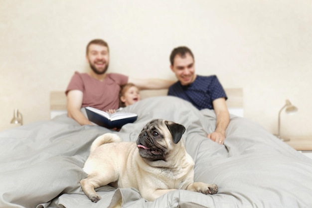 Couple gay masculin avec enfants se reposant dans son lit à la maison