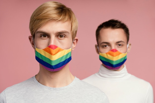 Photo couple gay avec masque médical arc-en-ciel