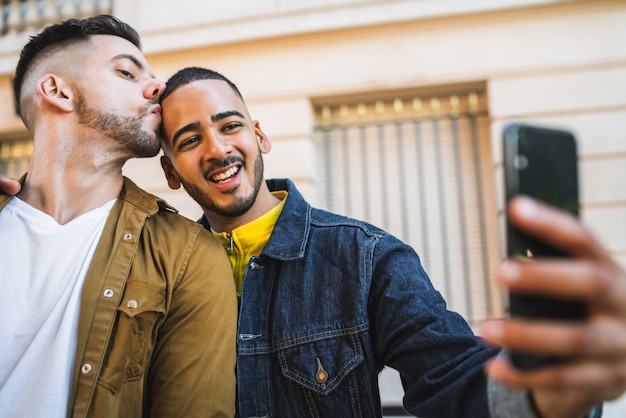 Couple gay prenant un selfie dans la rue.